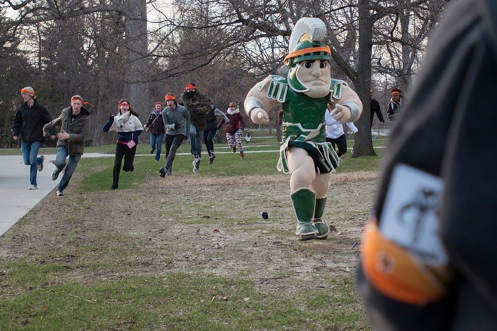 <p>Sparty joins the zombies to attack the humans April 15, 2014, at Beaumont Tower during Spartans vs. Zombies. Zombies can be identified by the bandanas around their head. Julia Nagy/The State News</p>