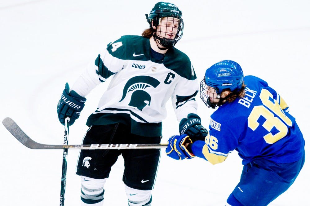 Junior defenseman Torey Krug grabs Alaska forward Colton Beck's stick and shares a few words with him Friday night at Munn Ice Arena. The spartans won 3-2 in an overtime thriller against the nonooks. Aaron Snyder/The State News. 