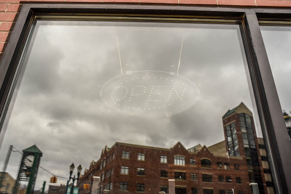A turned off "Open" sign in downtown East Lansing on April 1, 2020.