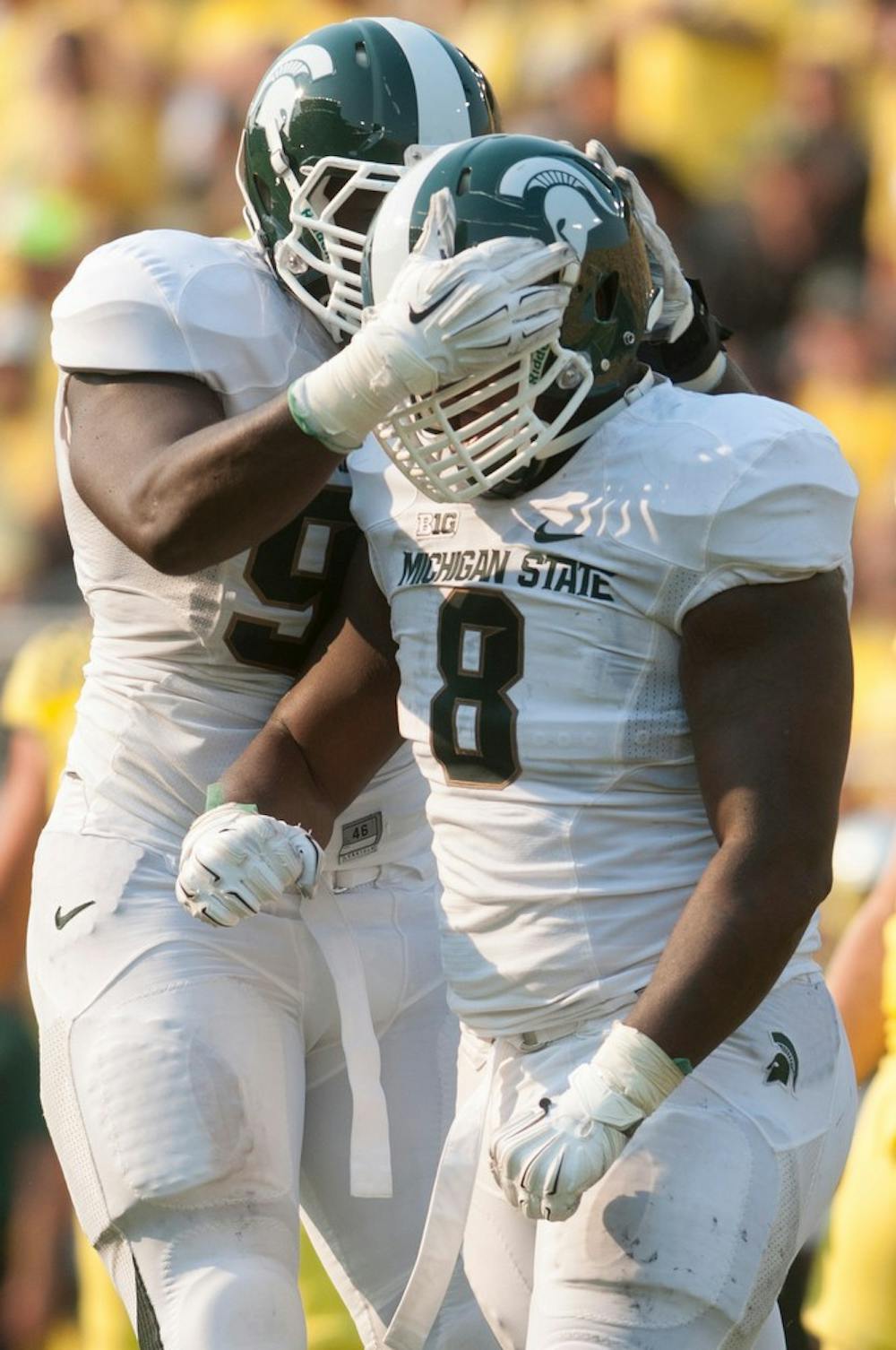 <p>Junior defensive linemen Joel Heath, left, and Lawrence Thomas celebrate a tackle Thomas made during the game against Oregon on Sept. 6, 2014, at Autzen Stadium in Eugene, Ore. Julia Nagy/The State News</p>
