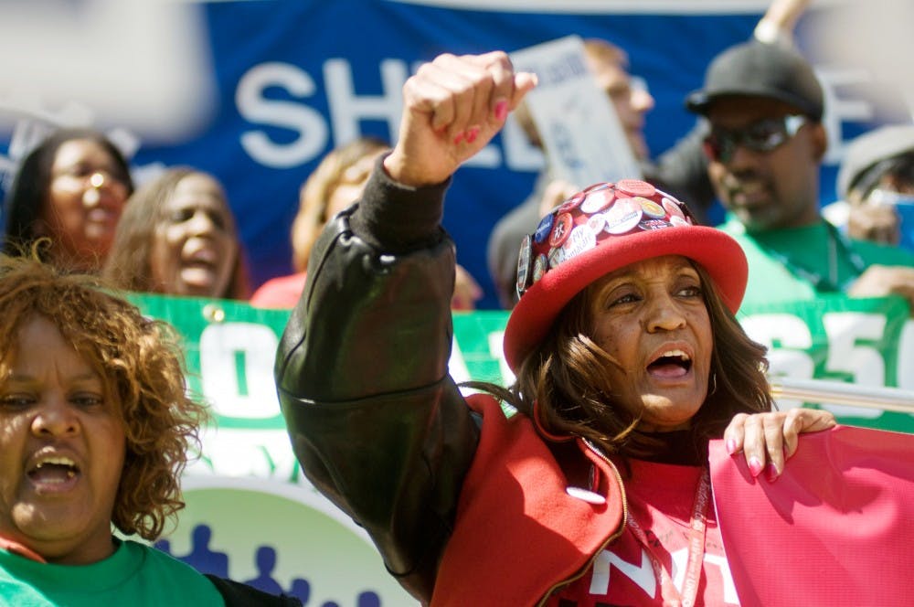 Detroit resident Lekarroll McCray yells, "This is what democracy looks like," with thousands of other protesters during a rally at the Capitol on Wednesday in Lansing. McCray was representing a hospitality union, Local 24, out of Detroit. Kat Petersen/The State News