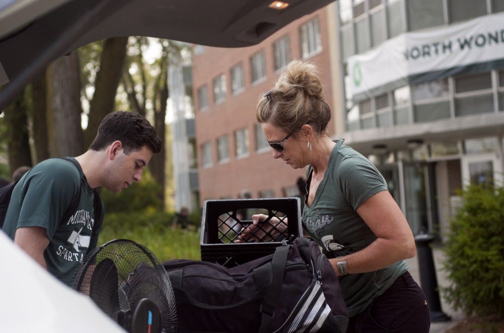 <p>Mechanical engineering sophomore Cameron Alvado moves into his dorm with the help of his mother Grand Blanc, Mich. resident Cindy Alvado on Aug. 31, 2015, at North Wonders Hall. Treasure Roberts/The State News</p>