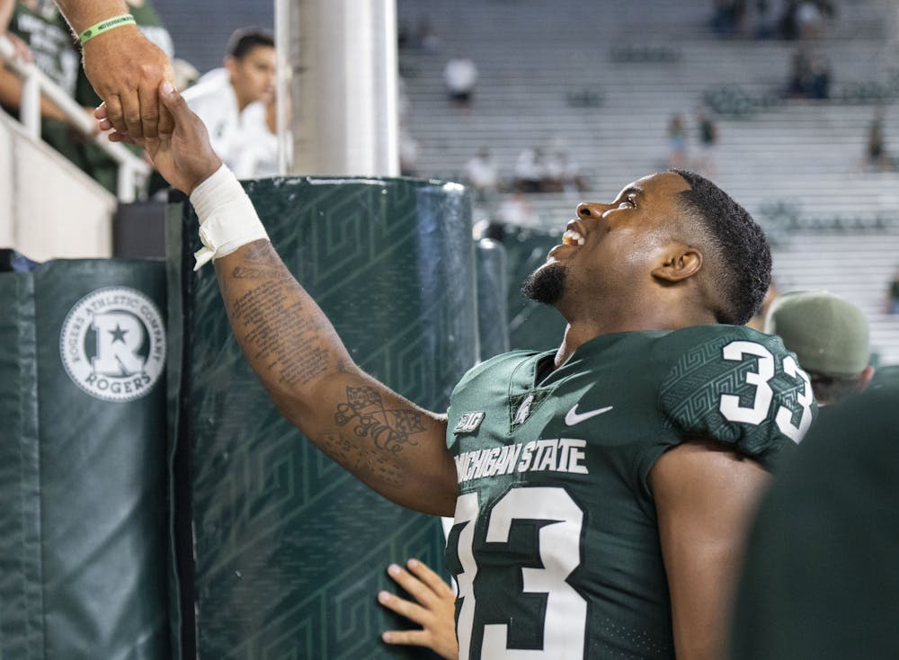 <p>Senior defensive back Kendell Brooks (33) shakes hands with a fan during Michigan State’s home opener against Western Michigan at Spartan Stadium on Sept. 2, 2022. The Spartans ultimately beat the Broncos, 35-13.</p>