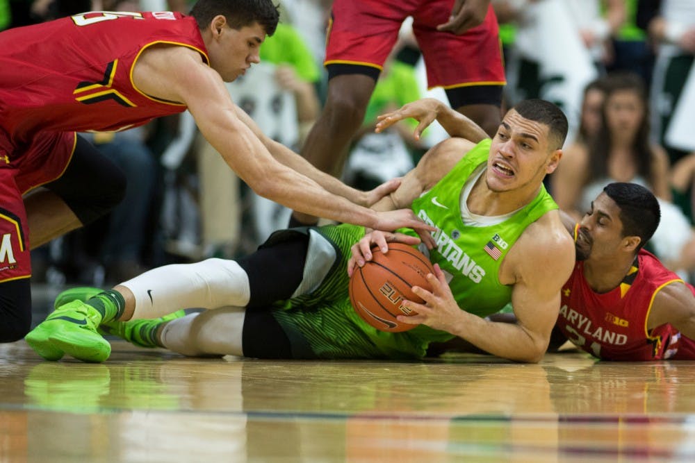 Junior forward Gavin Schilling grabs the ball from the floor as he is tackled by Maryland guard/forward Varun Ram, 21, and Maryland forward Michal Cekovsky during the game against Maryland on Jan. 23, 2016 at Breslin Center. The Spartans defeated the Terrapins, 74-65.