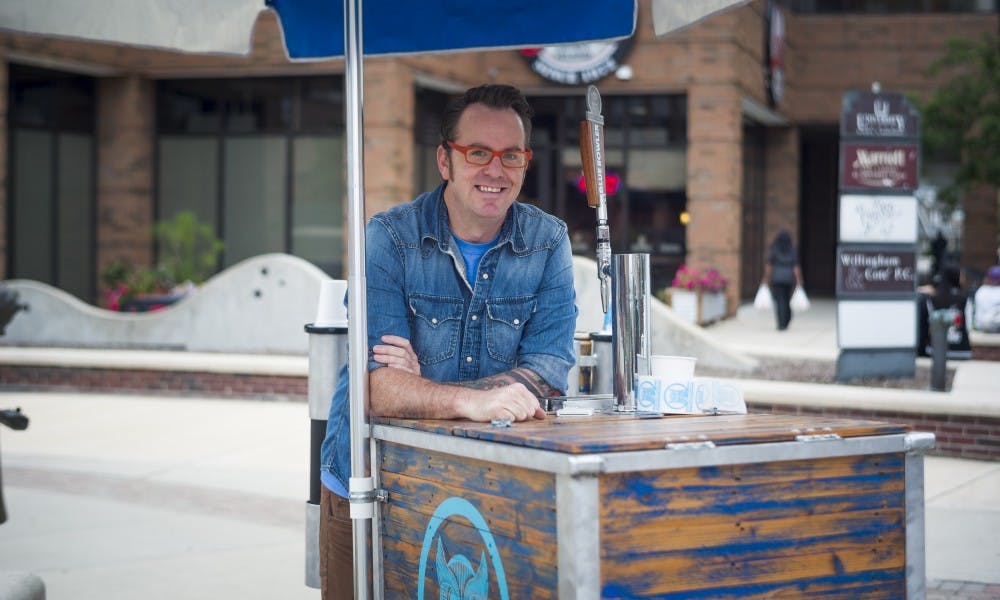 <p>Lansing resident Nick Berry poses for a picture while working his coffee stand on Aug. 29 on the corner of Albert Ave. and M.A.C. Ave. Berry, the owner of the coffee stand said "It's a conversation starter. Everyone tastes something different in every cup, so you just start there and then you start talking about how &nbsp;your day is going and how your life is going."</p>