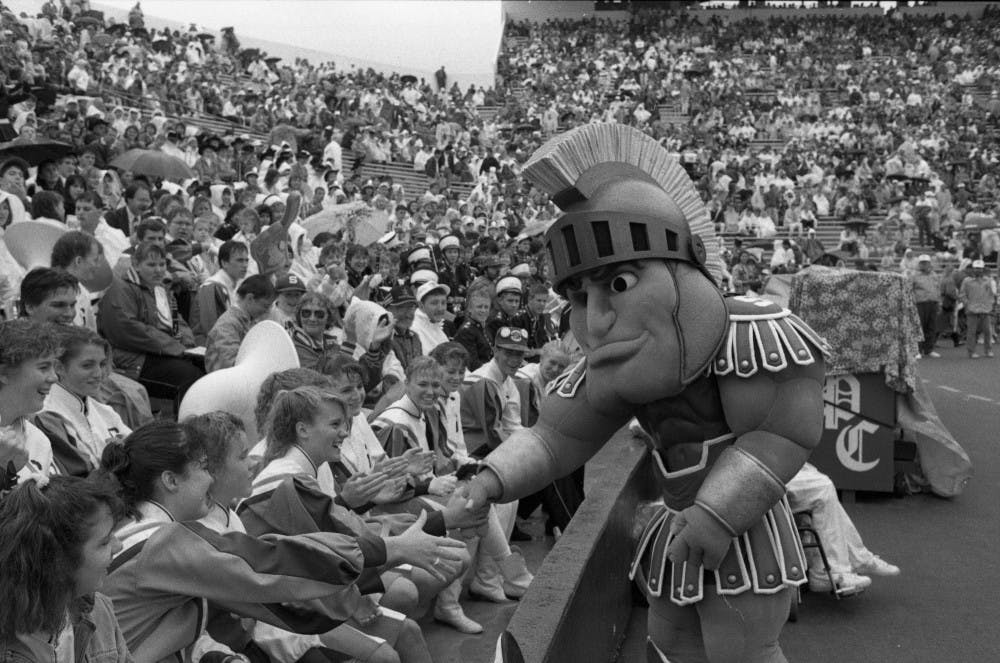 <p>An early version of the modern Sparty costume greets fans at a game in September 1989. Photo courtesy of the MSU University Archives and Historical Collections and Ben Zolynsky.&nbsp;</p>