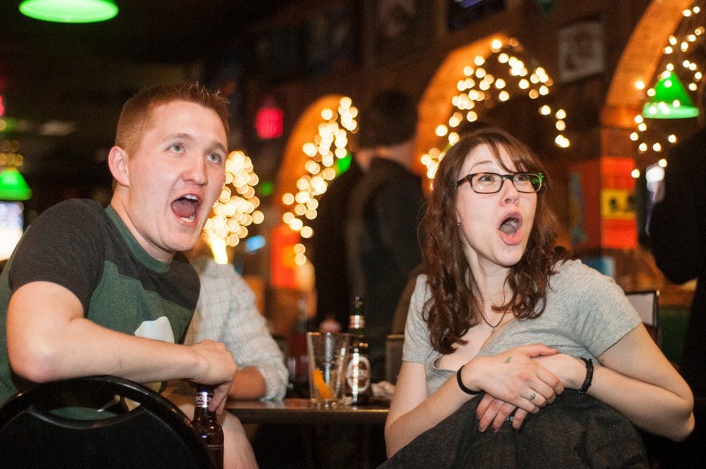 <p>Then-Law graduate student Scott Chu, left, and then- alumnus Pamela Wall, right, shout during the Michigan v. Kansas basketball game on Friday, March. 29, 2013, at Crunchy's, at 254 W Grand River Ave,. The friends were hoping for a Michigan win for the chance of seeing a Michigan-Michigan State game. Danyelle Morrow/The State</p>