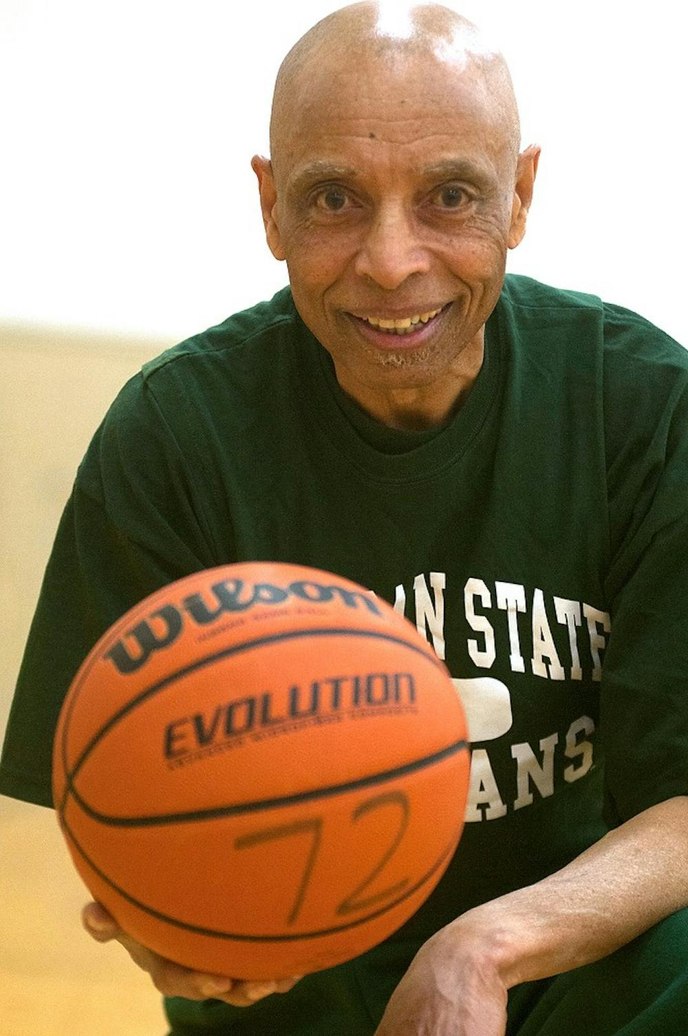 <p>East Lansing resident and 1965 MSU alumnus James E. Cummings Jr. poses with a basketball April 22, 2015, at IM West in the gym where he had a heart attack three and a half years ago. Cummings comes to the gym nearly every day to practice his shot and play HORSE with "young spartans." Kennedy Thatch/The State News</p>