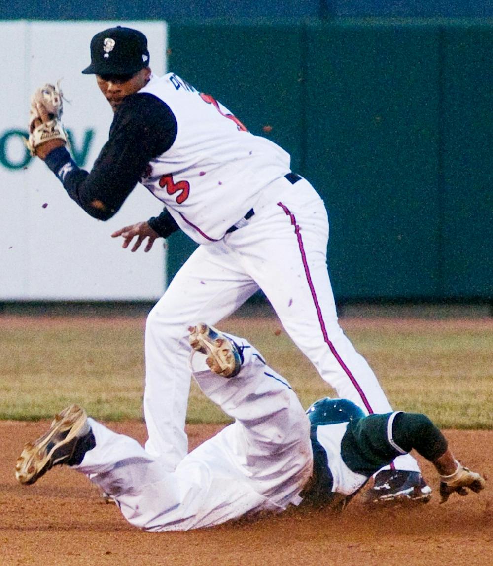 Sophomore left fielder Jordan Keur slides into second base with a steal under the tag of Lansing shortstop Garis Pena Tuesday at Cooley Law School Stadium. The Spartans defeated the Lugnuts, 2-1, in the fifth annual Crosstown Showdown. Matt Radick/The State News
