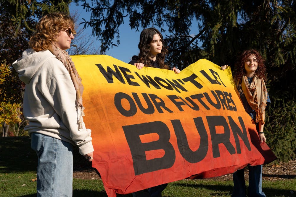 <p>Michigan State University students Phoebe Bosch, Reidun Johnson, and Lydia Woods hold up a banner during the Students United Against Fascism protest against 2024 president-elect Donald Trump at Demonstration Hall Field on Nov. 8, 2024. SUAF is a coalition of progressive groups at MSU that organize against fascism.</p>