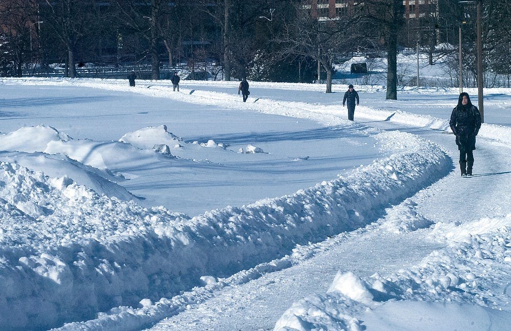 <p>Students make their way to and from classes in the depths of snow and chilly weather Feb. 2, 2015. Camille Douglas/The State News</p>