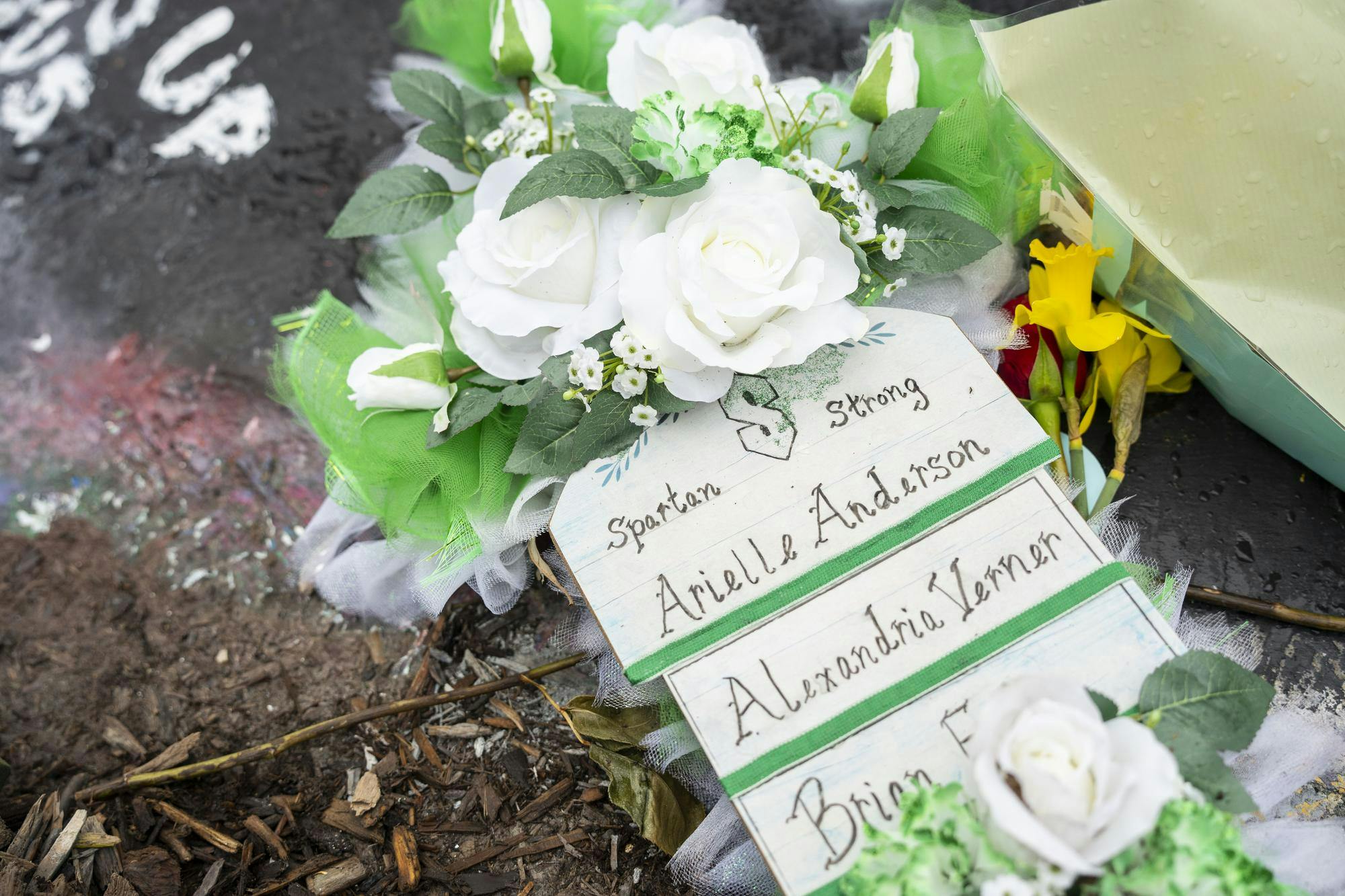 <p>A sign lays at the foot of the Rock on Farm Lane in memorial of Arielle Anderson, Alexandria Verner and Brian Fraser on April 5, 2023 - about seven weeks after the shooting in MSU’s north campus that took their lives and hospitalized five other students.&nbsp;</p>