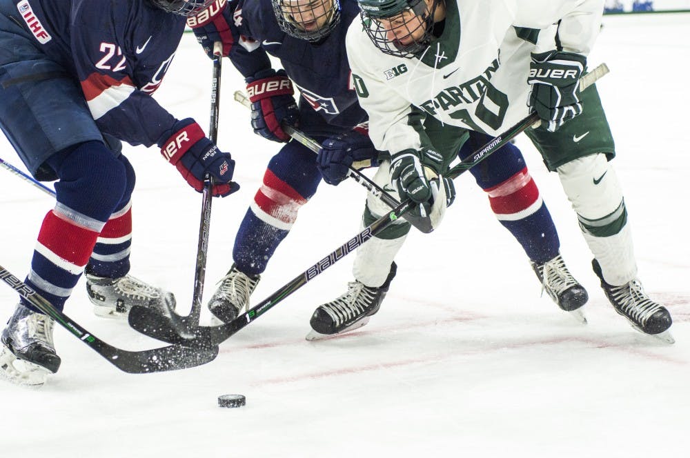 Freshman center Sam Saliba (10), USA forward Josh Norris (14) and USA defenseman Phil Kemp (22) go after the puck during the first period in the exhibition game against U.S. National Team Development Program U-18 Program on Dec. 4, 2016 at Munn Ice Arena. The Spartans led the first period, 2-1.