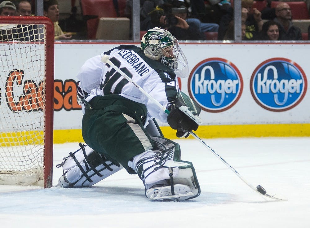 <p>Junior goaltender Jake Hildebrand stops the puck during the game against Ferris State on Dec. 28, 2014, during the 50th Great Lakes Invitational at Joe Louis Arena in Detroit. Hildebrand stopped 31 shots in his first season shutout. Danyelle Morrow/The State News</p>
