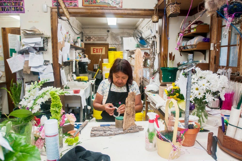 Lansing resident Raquel Sanchez puts together a floral arrangement at B/A Florist, 1424 E. Grand River Ave., on Monday, July 23, 2012. Sanchez, a flower designer, said she loves her job because she is able to play with the flowers and be creative. Samantha Radecki/The State News