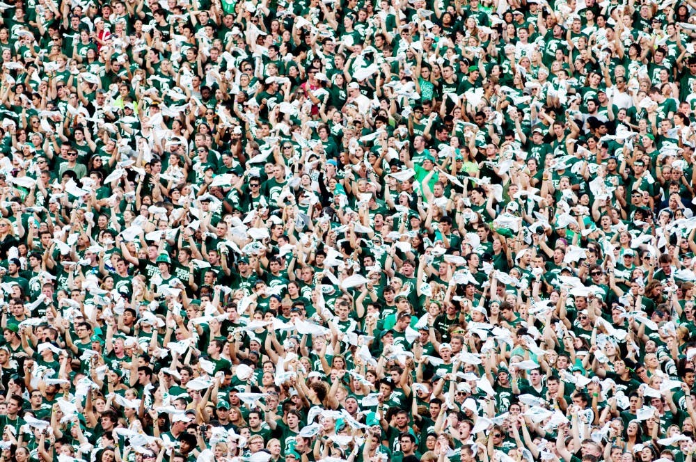 Members of the student section wave their white spirit towels as they cheer while the Spartans play against the Penguins. The Spartans defeated Youngstown State, 28-6, Friday night at Spartan Stadium. Josh Radtke/The State News