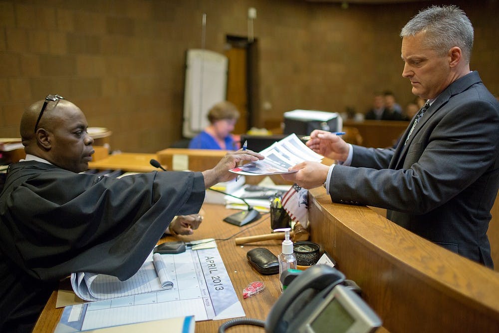 	<p>Judge Allen, left, receives evidence from Ingham County Assistant Prosecutor John Dewane, during the preliminary exam for the teen accused of stabbing <span class="caps">MSU</span> student Andrew Singler to death, April 18, 2013, at Ingham County District Judge Donald Allen&#8217;s courtroom in Mason, Mich. Natalie Kolb/The State News</p>