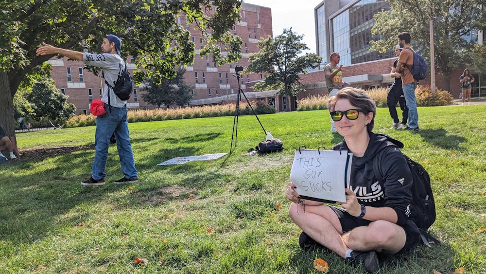 <p>MSU Movement member and mechanical engineering sophomore Lucas Trainor peacefully fights back against preachers by Wells Hall on Sept. 20, 2023.</p>