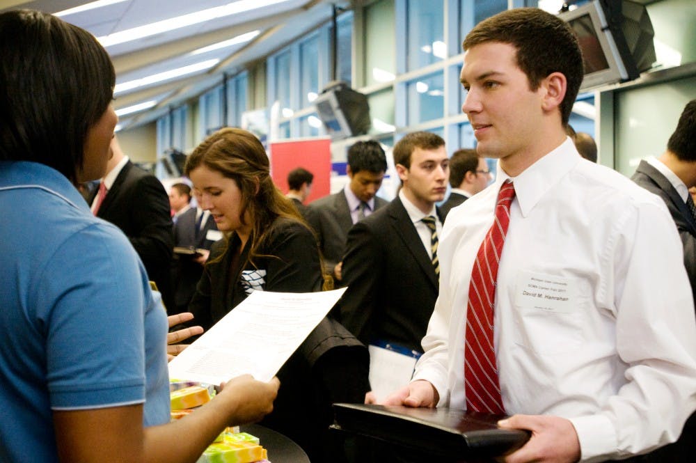 Supply chain management sophomore David Hanrahan speaks to a representative from Kimberly-Clark at a supply chain management career fair Wednesday at Spartan Stadium.  Katy Joe DeSantis/The State News