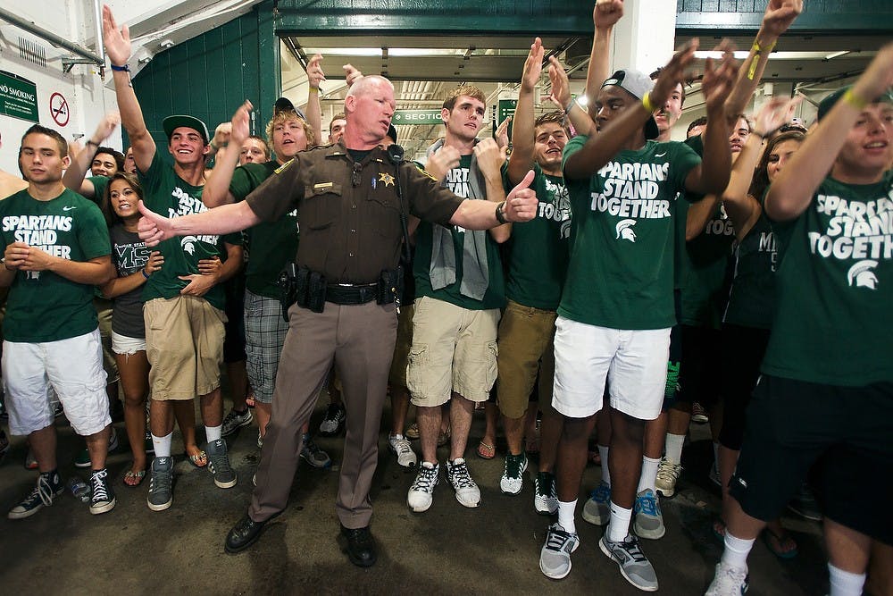 	<p>An officer tries to keep order as students start a chant during the weather delay during the game against University of South Florida  Sept. 7, 2013, at Spartan Stadium. Parts of the student section refused to leave the stadium after they were asked to evacuate to Wells Hall. Julia Nagy/The State News</p>