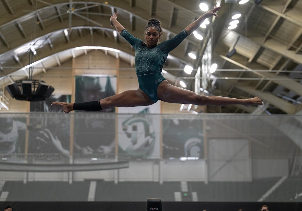 MaKayla Tucker, junior, performs a twisting jump on the balance beam during the MSU tri-meet at Jenison Field House on Sunday, Feb. 15, 2026.