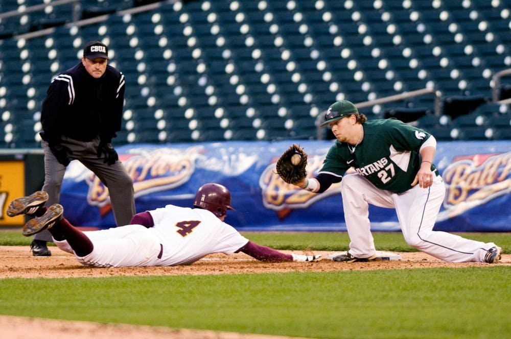 	<p>Senior first baseman Jeff Holm attempts to tag out Central Michigan catcher William Arnold Wednesday at Comerica Park in Detroit. The Spartans defeated the Chippewas 3-1. Matt Radick/The State News</p>