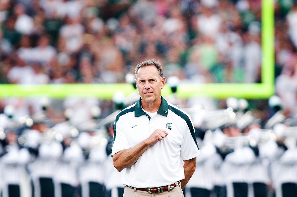 <p>Head coach Mark Dantonio holds his hand over his heart during the national anthem Sept. 2, 2011, at Spartan Stadium. Matt Radick/The State News</p>