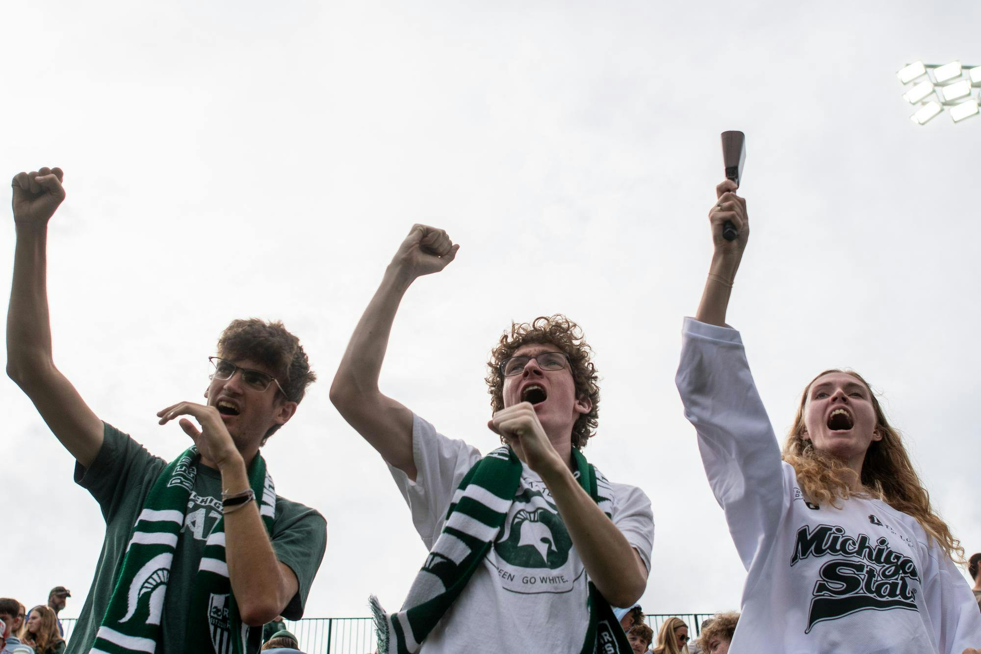 <p>MSU soccer student section leaders, Ryan Chenoweth, 20, Eli Flikkema, 19, and Mikayla Datka, 19, cheer during the MSU versus USC women's soccer game at Michigan State University's DeMartin Soccer Stadium on Sunday, Sept. 21, 2025.</p>