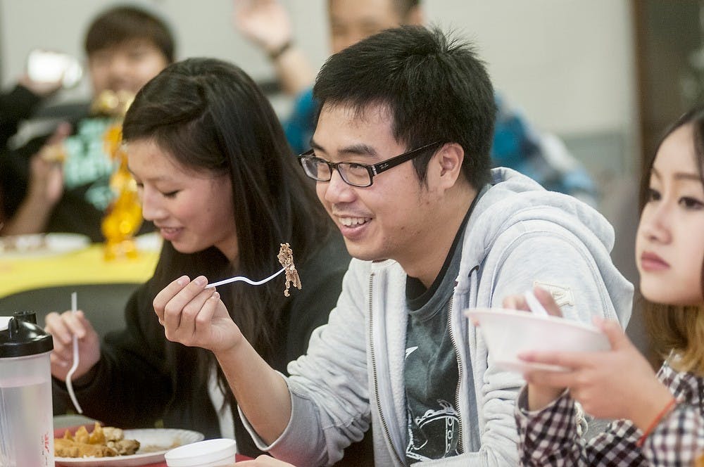 	<p>Computer science senior Michelle Truong, left, and clinical laboratory sciences senior Thinh Nguyen, right, eat homemade Vietnamese food as they talk with friends at the Vietnamese Student Association&#8217;s meeting on Tuesday, Nov. 20, 2012, in the Vincent Chin room of Holden Hall. Members of the association spent the evening socializing before leaving for the holiday break. Danyelle Morrow/The State News</p>