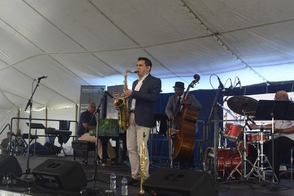 <p>Diego Rivera, Assistant Professor of Jazz Saxophone and Improvisation at Michigan State University, playing the saxophone with Rodney Whitaker and Soul-R-Energy during the East Lansing Summer Solstice Jazz Festival near Ann Street Plaza June 19th. 2015. Wyatt Giangrande/The State News</p>