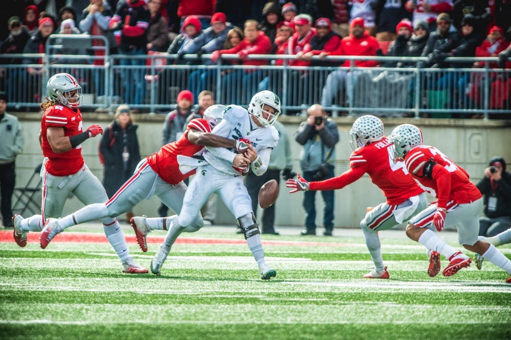 <p>Sophomore quarterback Brian Lewerke (14) fumbles the ball during the game against Ohio State, on Nov. 11, 2017, at Ohio Stadium. The Spartans trail the Buckeys, at the half 3-35.</p>