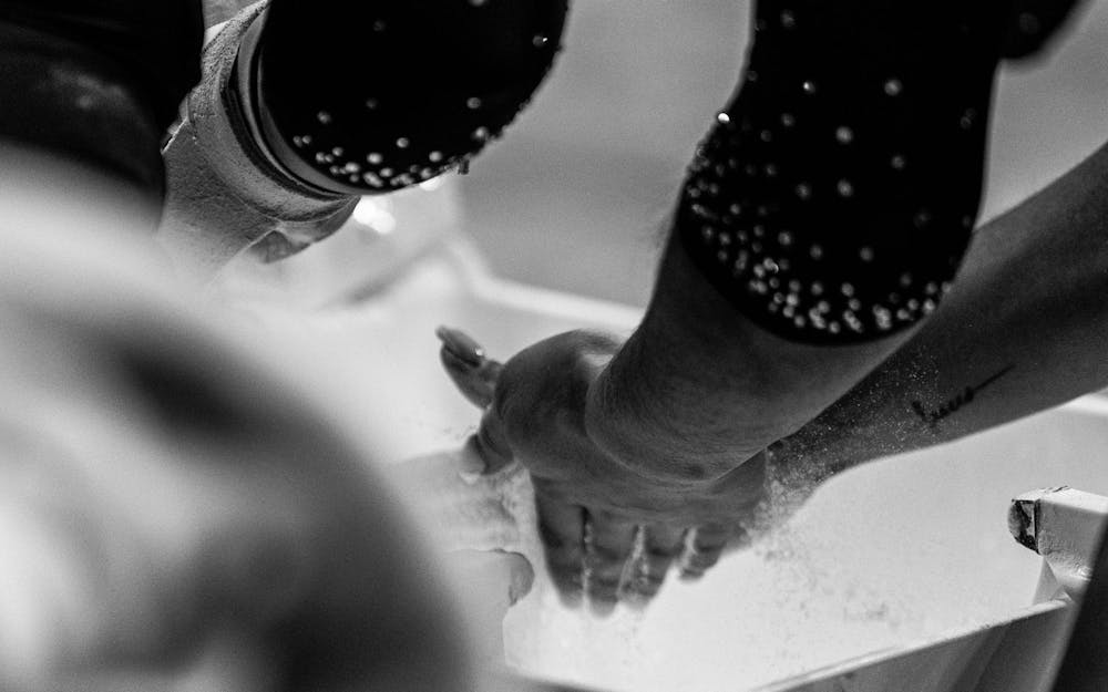 MSU gymnasts chalking hands during the MSU v WMU v UMD at Jenison Field House in East Lansing, on Feb. 15th, 2026.