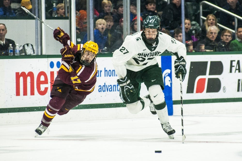 Sophomore forward Mason Appleton (27) and Minnesota forward Tommy Novak (17) go after the puck during the second period in the game against Minnesota on Dec. 9, 2016 at Munn Ice Arena. The Spartans were defeated by the Gophers, 4-2.