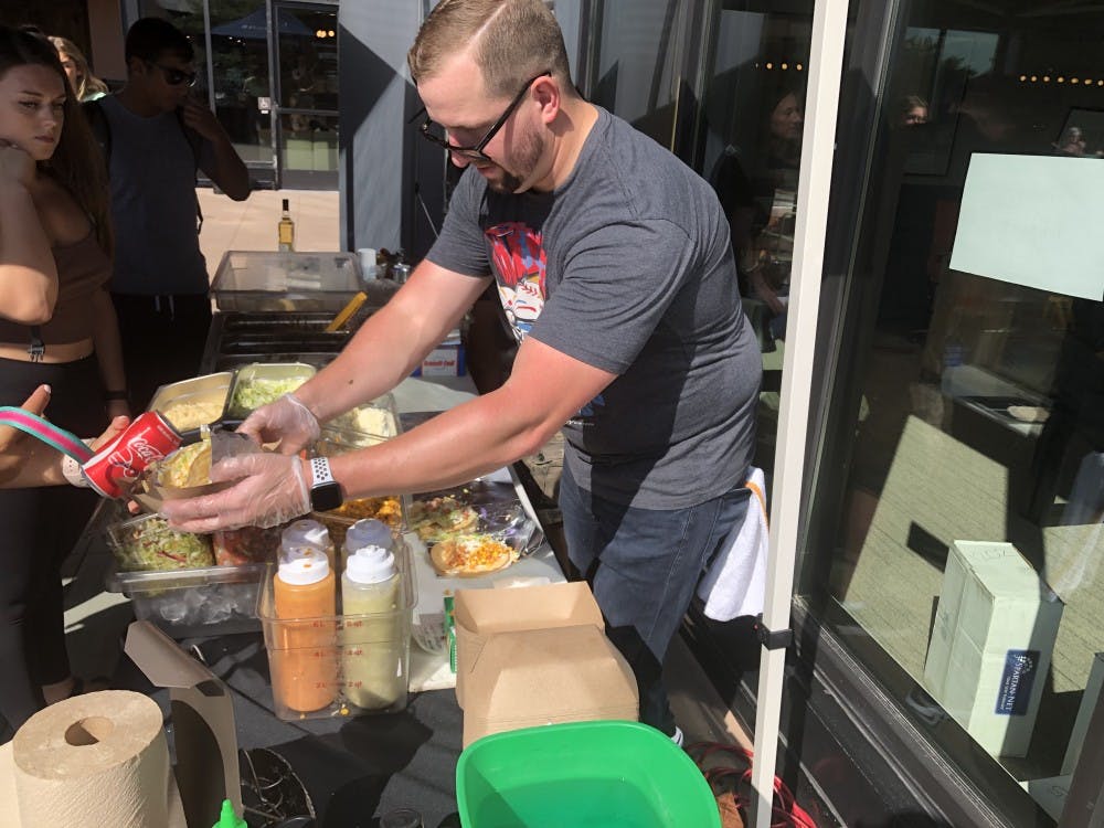 <p>Jake Hawley prepares tacos for Landmark residents. </p>