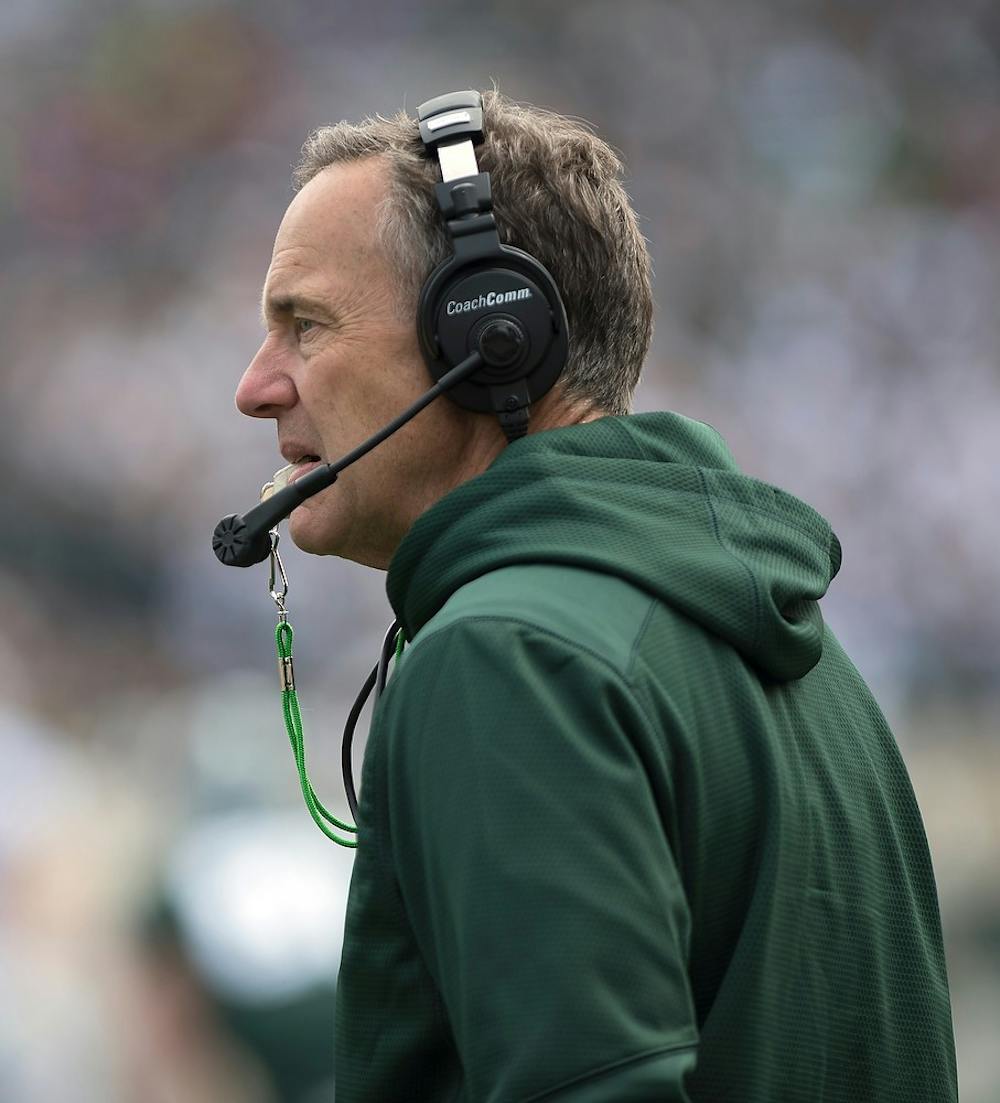 <p>Head coach Mark Dantonio watches his team on the field April 25, 2015, during the Green and White Spring game at Spartan Stadium. The white team defeated the green team, 9-3. Erin Hampton/The State News</p>