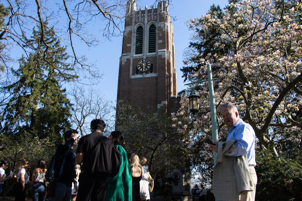 Michigan State University graduates and others wait in line to take photos in front of Beaumont Tower on campus in East Lansing, Mich., Tuesday, April 22, 2026.