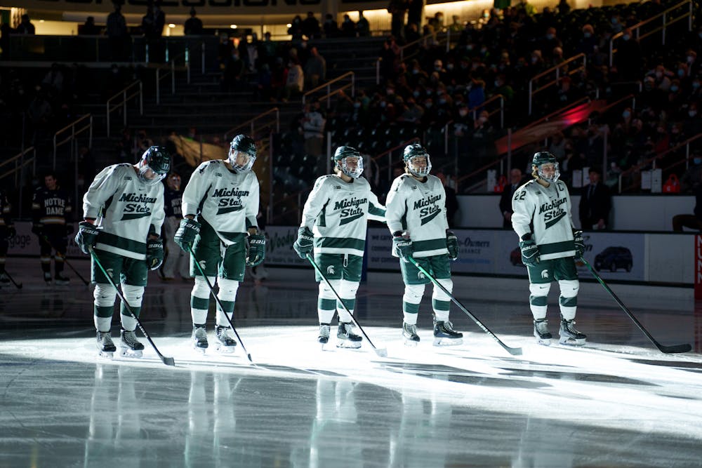 <p>Michigan State hockey players freshman David Gucciardi, senior Adam Goodsir, sophomore Nash Nienhuis, sophomore Kristof Papp and senior Dennis Cesana during introductions before their game against Notre Dame on Feb. 18, 2022. Spartans lost 2-1 against Notre Dame. </p>