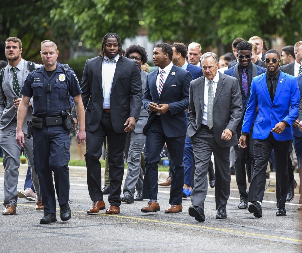 Head coach Mark Dantonio and the football team walk to the stadium before the homecoming game against Indiana on Sept. 28, 2019 at Spartan Stadium. 