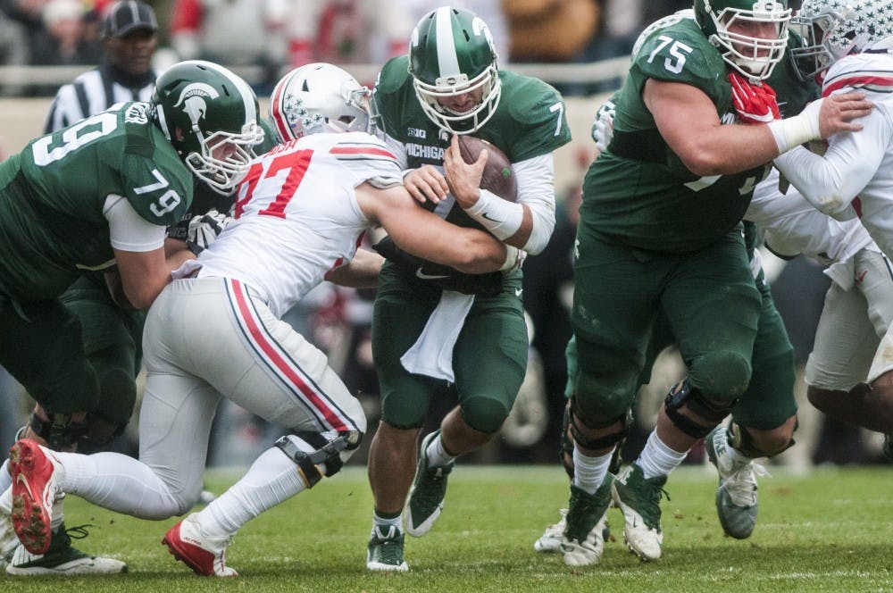 <p>Senior quarterback Tyler O'Connor (7) is tackled by Ohio State defensive end Nick Bosa (97) during the first half of the game against Ohio State on Nov. 19, 2016 at Spartan Stadium. The Spartans were defeated by the Buckeyes, 17-16.</p>