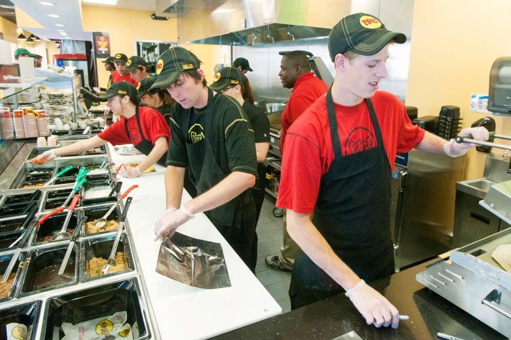 Laingsburg, Mich. resident Corey Olney, right, heats up a tortilla on Wednesday afternoon inside Moe's Southwest Grill, of 551 E. Grand River Ave. The restaurant, opened last Thursday offeres a variety of Mexican food including burritos and tacos. Justin Wan/The State News