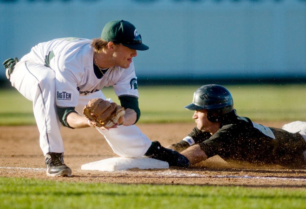 	<p>Sophomore third baseman Andrew Carpenter attempts to tag out Oakland infielder Ryan Waldhart as Waldhart successfully steals third base last Tuesday at Cooley Law School Stadium in Lansing. The Spartans will look to sweep two games against in-state opponents Western Michigan and Central Michigan this week. </p>