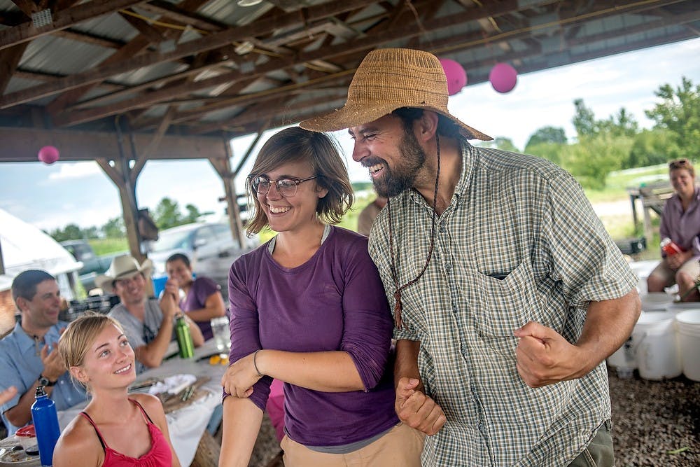 	<p>Propagation manager Kate Heflick and director Jeremy Moghtader, who teamed up in the third annual Sausage Throwdown, smile after placing in the contest, July 23, 2013, at <span class="caps">MSU</span> Student Organic Farm during the third annual Sausage Throwdown. Each student of the organic farmer training program came up with a sausage recipe for the annual competition. Justin Wan/The State News</p>