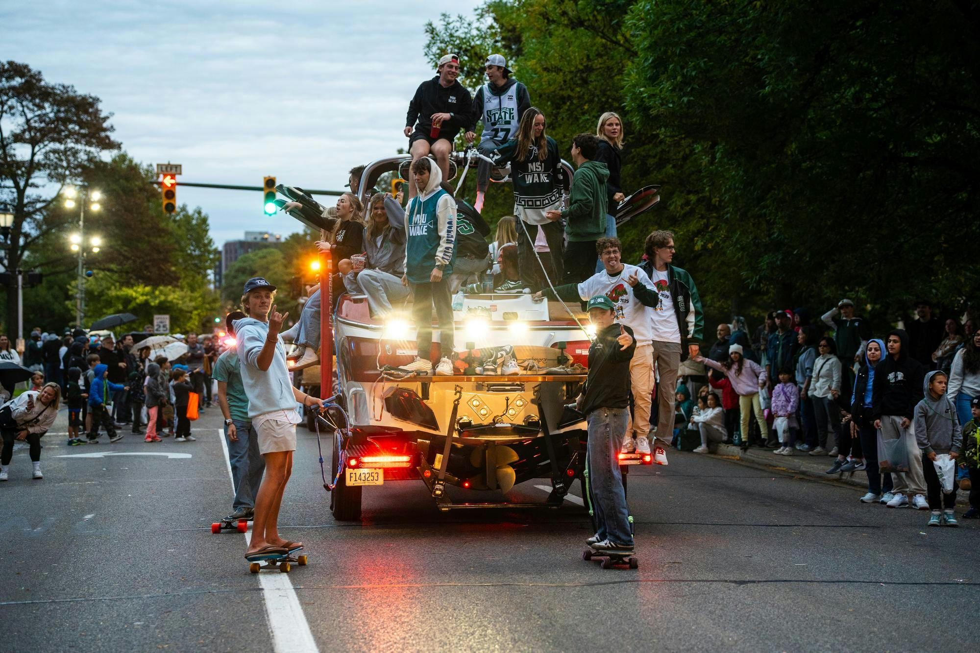 Members of Michigan State University’s Wake Club ride their homecoming float down Grand River Avenue while playing music and interacting with paradegoers on Oct. 10, 2025, in East Lansing, Michigan.