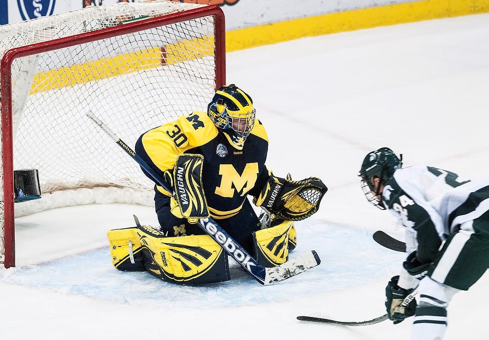 	<p>Wolverine goaltender Adam Janecyk braces himself as redshirt freshman Justin Hoomaian crashes the net Sunday, Dec. 30, 2012, at Joe Louis Arena in Detroit. The Wolverines defeated the Spartans 5-2 during the Great Lakes Invitational third place game. Adam Toolin/The State News</p>