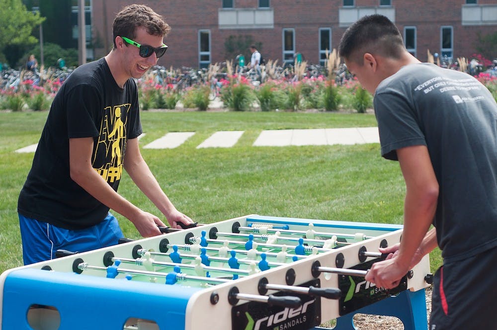	<p>Hospitality business juniors Andrew Dike, left, and Rodney Weng, right, practice their foosball skills before the foosball tournament Sept. 18, 2013, outside of Wells Hall. Rider Sandals has been touring various colleges in the East/Midwest holding foosball tournaments and will be on the West coast in the spring. The winner of the tournament wins a check for $100. Margaux Forster/The State News</p>