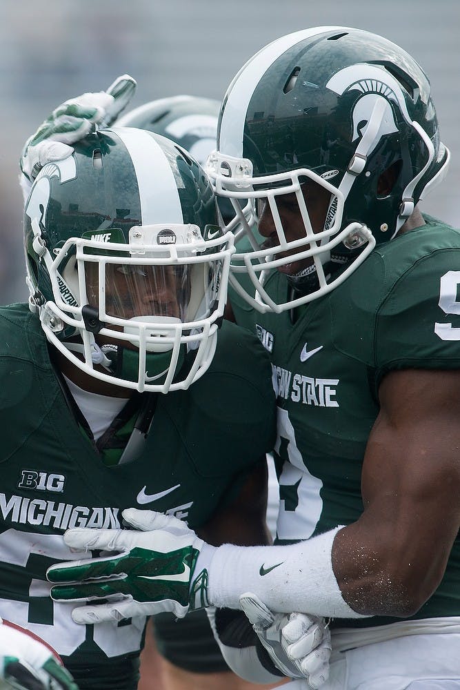 <p>Sophomore cornerback Jermaine Edmondson, left, and defensive back Montae Nicholson celebrate Edmondson recovering an Eastern fumble Sept. 20, 2014, at Spartan Stadium. The Spartans defeated the Eagles, 73-14. Julia Nagy/The State News</p>