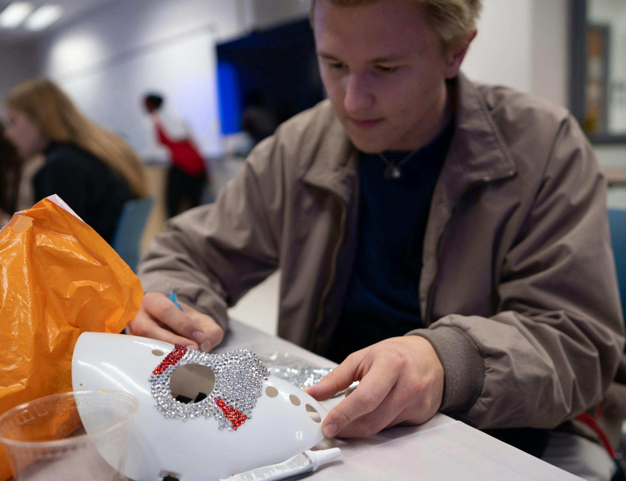 <p>Materials engineering junior Zack Zeller bedazzles a Jason Vorhees hockey mask before entering the Haunted Holmes hallway with friends on Oct. 24, 2024.</p>