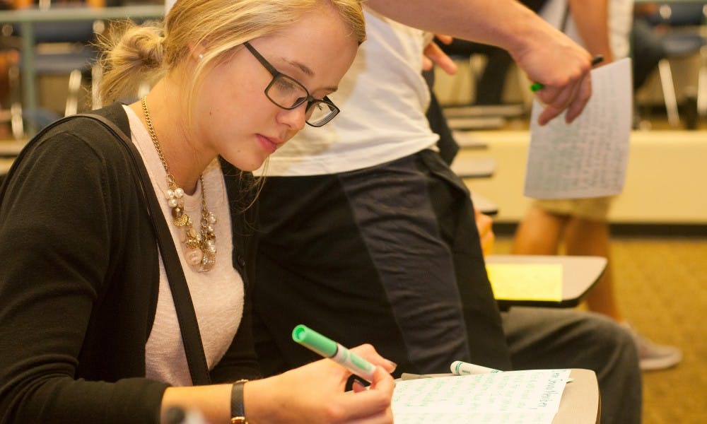 <p>Advertising freshman Audrey Shaefer writes a note to the military troops on Sept. 21, 2015, inside the Erickson Kiva room. Shaefer volunteered in high school with the program Students Against Destructive Decisions (SADD) and heard about this club from a friend. "It's really nice to be a part of something bigger and to be a part of something bigger," Shaefer said. Joshua Abraham/The State News</p>
