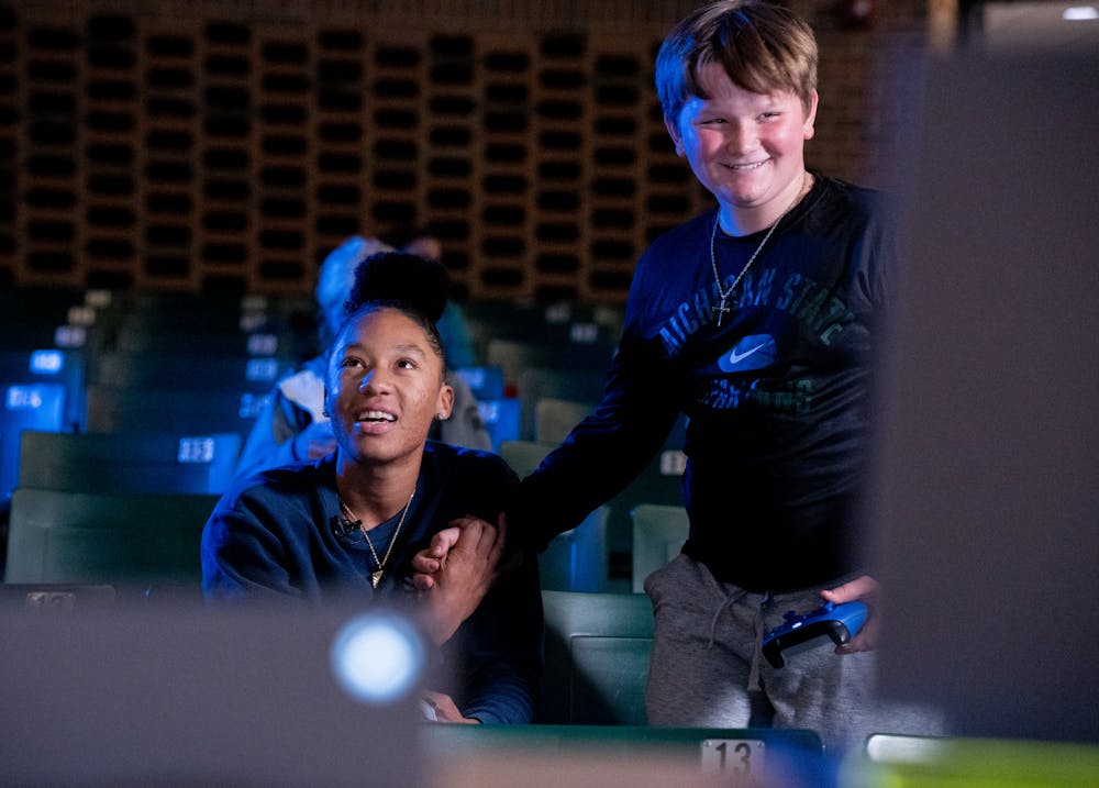 <p>Minnesota Lynx small forward Aerial Powers greets Brady Merchant, son of Michigan State women&#x27;s basketball head coach Suzy Merchant, as they play Call of Duty Warzone in the Communication, Arts and Sciences building on April 7, 2022. Powers returned to Michigan State, where she hails as a Big Ten Champion, to host the gaming event.</p>