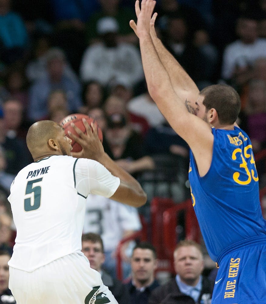 <p>Senior center Adreian Payne shoots the ball while guarded by Delaware forward Carl Baptiste on March 20, 2014, at Spokane Veterans Memorial Arena in Spokane, Wash., during the Spartans' first game in the NCAA Tournament. MSU won, 93-78 . Betsy Agosta/The State News</p>